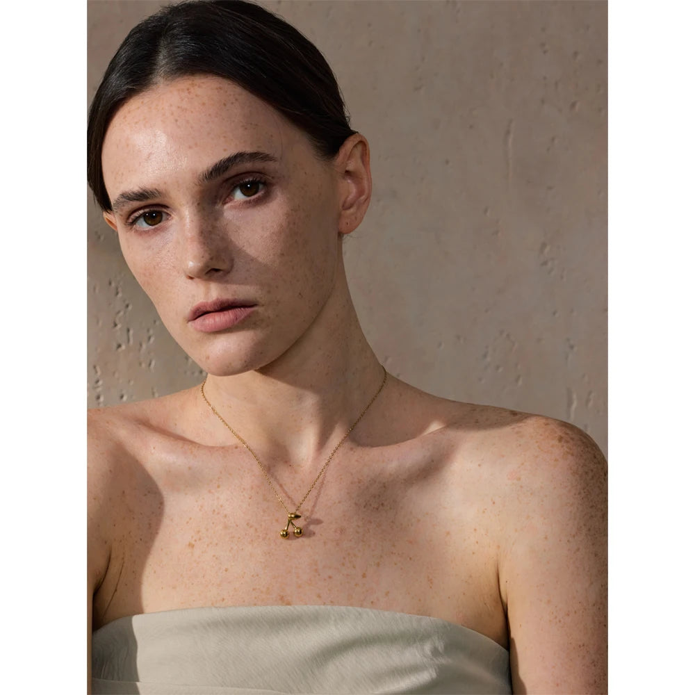 Cerise necklace styled with a playful glossy accent